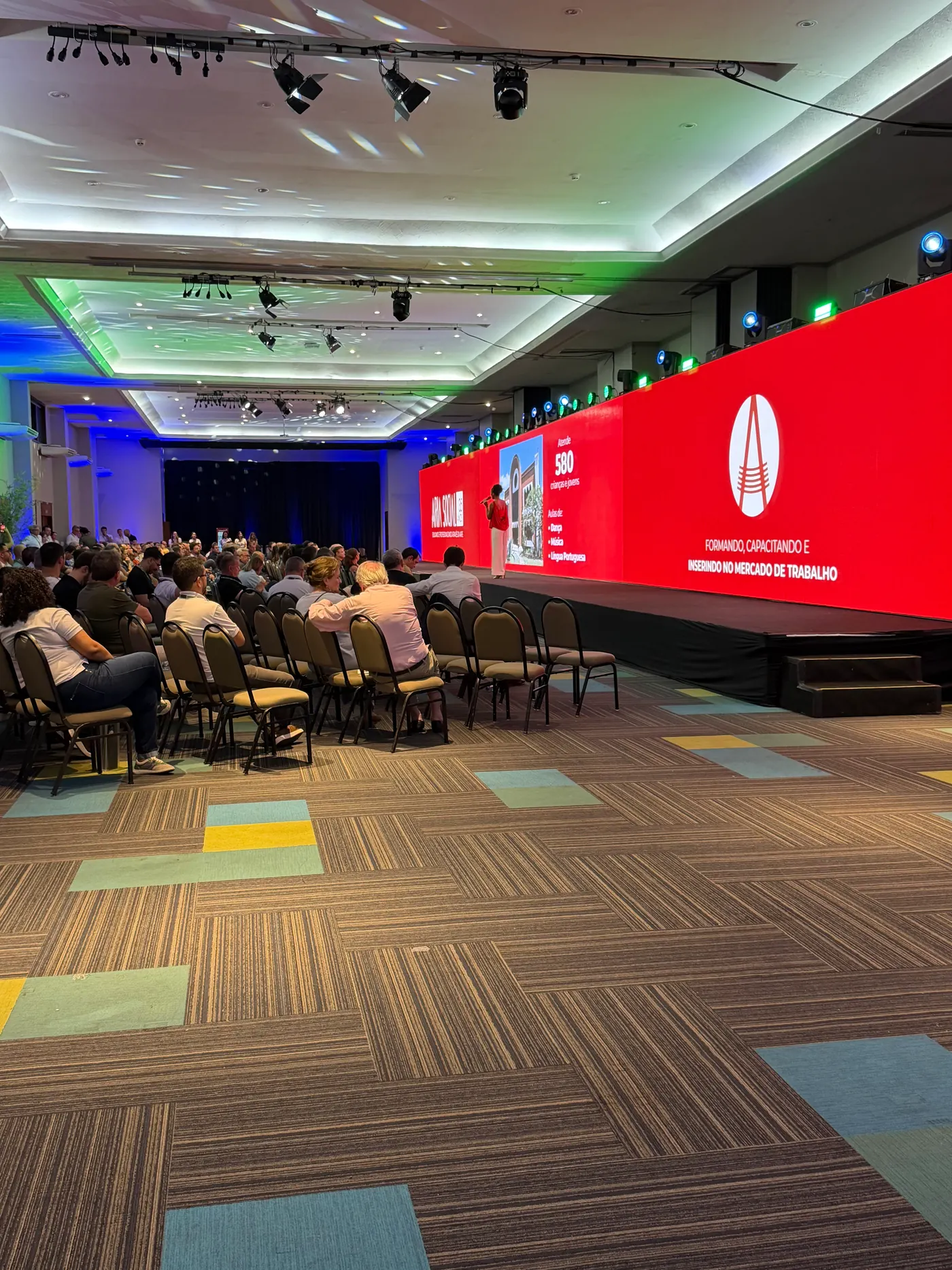 Painel de LED panorâmico e iluminação em evento corporativo atendido pela Bispo Eventos